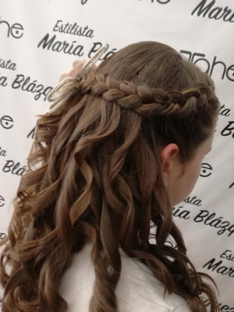 Semirecogido niña con trenzas y ondas con flor en le lateral para comunión